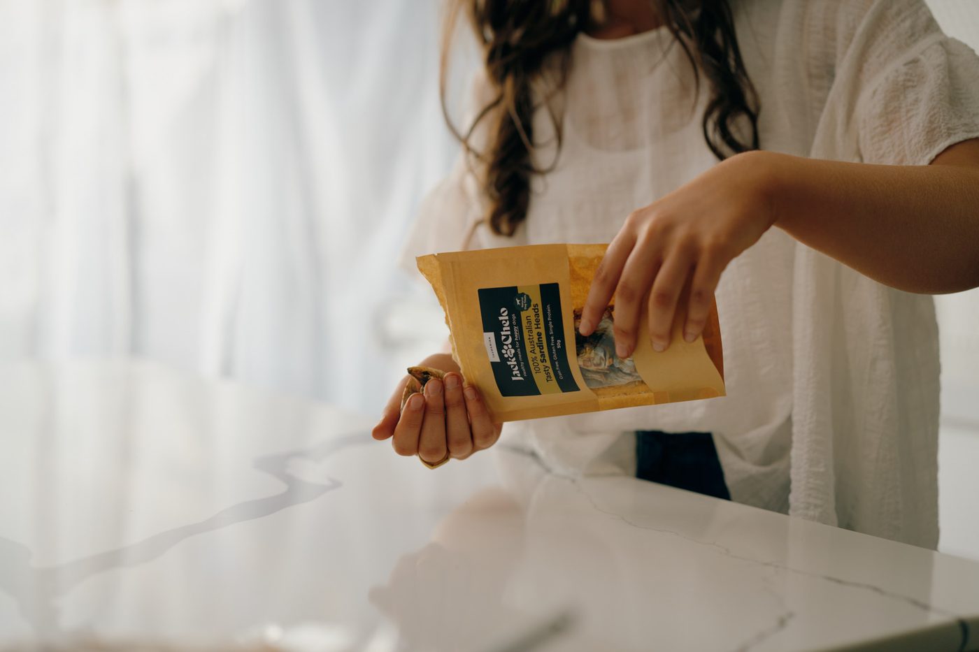 Pouring treats from a Jack and Chelo treat pack